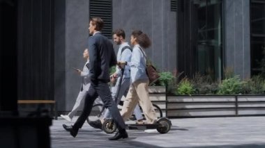 Şehir merkezinde bisiklet kickscooter 'ı tutan kurumsal insanlar. Yeşil taşıma.