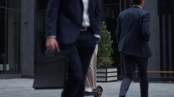Ragazza attraente cavalcando scooter elettrico nel quartiere del centro. Stile di vita urbano. — Video Stock