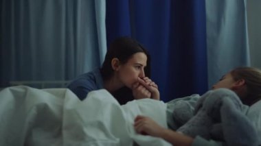 Modern hastane koğuşunda cerrahi tedaviden sonra hasta kızına bakan anne.. 