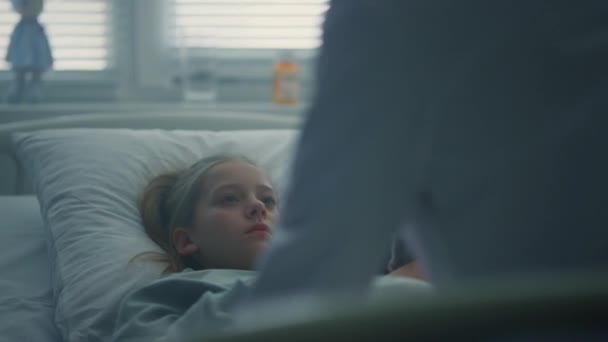 Retrato menina deitado hospital cama abraçando brinquedo. Médico visitando paciente na enfermaria. — Vídeo de Stock
