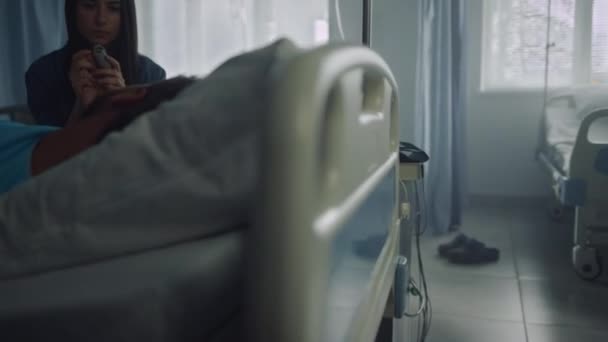 Támogató nő kórházi kórterem eszméletlen beteg kezével műtét után. — Stock videók