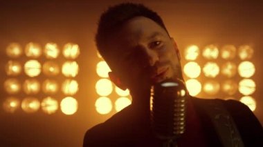 Şarkıcı adam gece kulübünde şarkı söylüyor. Vokalist sahnede solo şarkı söylüyor.