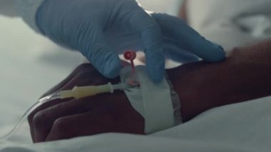Doktor serum takıyor. Enjeksiyonu yakın çekim yapıyor. Hastane yoğun bakım ünitesi.
