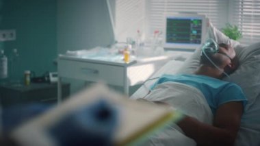 Yatağında oksijen maskesi olan hasta bir hasta. Doktor tıbbi geçmişini kontrol ediyor. Yakın plan.