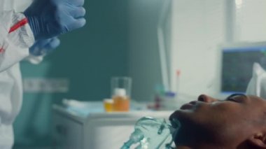 Hemşire koruyucu giysiyle ağız temizleme çubuğu alıyor. Eldivenler, bulaşıcı hastalıklar bölümü, yakın çekim..