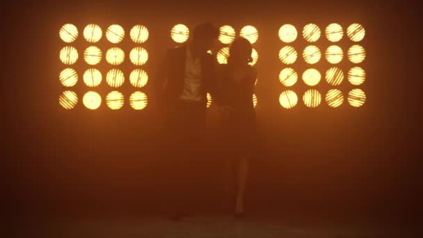 Сексуальная пара, идущая вместе, держась за руки на сцене. Молодая пара позирует в помещении. — стоковое видео