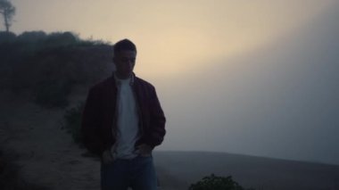 Güneş doğarken kumsalda yürüyen depresif bir adam. Denizde yürümekten hoşlanan adam 