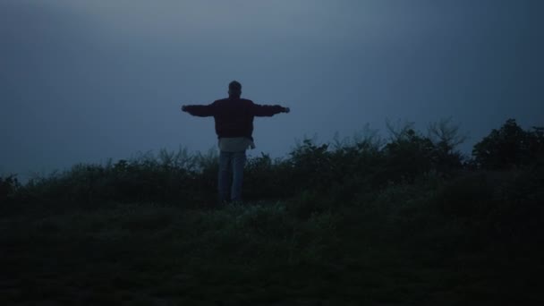 Μοναχικός τύπος που περπατάει στο ομιχλώδες χωράφι. Πίσω άνθρωπος προβολή σηκώνοντας τα χέρια στον αέρα — Αρχείο Βίντεο