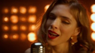 Gece kulübü ışıklarında şarkı söyleyen portre kadın. Bayan içeride gösteri yapıyor..