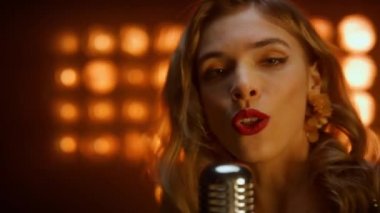 Sarışın kız gece kulübünde mikrofon şakıyarak şarkı söylüyor. Kız şarkıcının portresi.