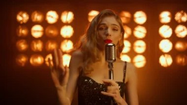 Sahnede dans eden göz kamaştırıcı kadın şarkıcı. Kız vokalist kulüpte şarkı söylüyor..