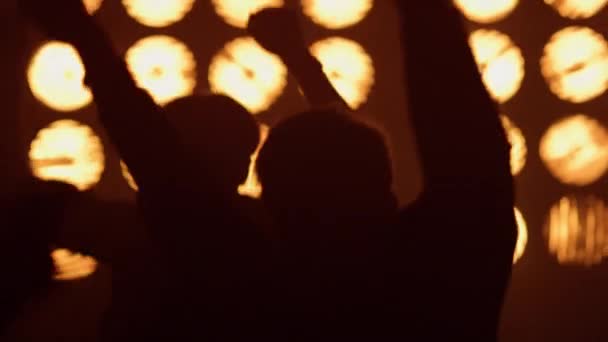 Sahne ışıkları altında kalabalık rock konseri. Heyecanlı insanlar zıplıyor. — Stok video