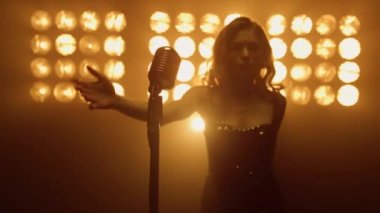 Seksi kadın mikrofonu al ve gece kulübü sahnesinde solo şarkı söylemeye hazırlan..