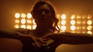 Gece kulübünde dans eden güzel bir kadın. Seksi kız saçlarına dokunuyor..
