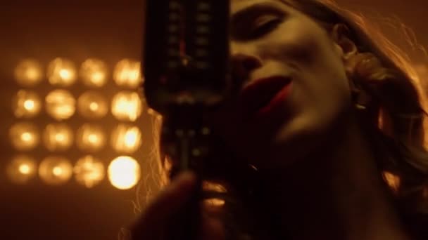 Wanita seksi bernyanyi solo di mikrofon dekat. Gadis yang tampil di lampu studio — Stok Video