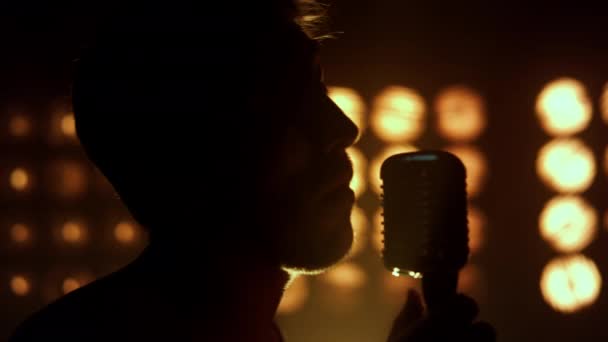 Siluetteki adam gece kulübünde şarkı söylüyor. Bilinmeyen vokalist. — Stok video