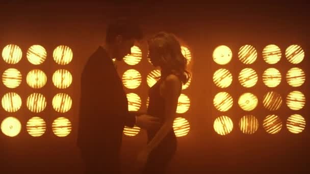 情侣们在聚光灯下表演情欲舞蹈.与男人激情相随的女人 — 图库视频影像
