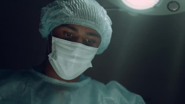 Focused surgeon performing surgical operation in intensive care unit portrait. — Stock Video