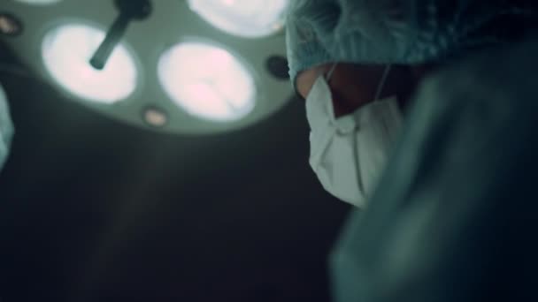 Portrait infirmière effectuer une opération tenant pince médicale dans la salle d'opération. — Video