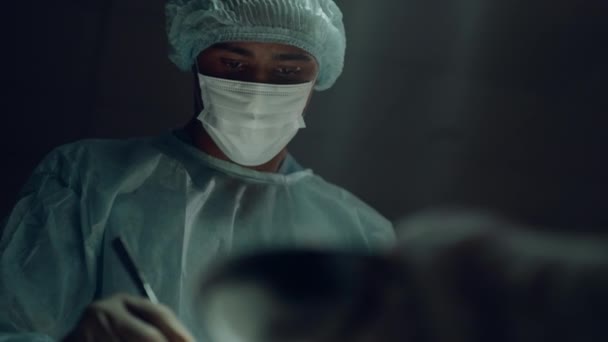Πορτρέτο αφροαμερικανός χειρουργός εκτελεί χειρουργική επέμβαση στο δωμάτιο κλινική. — Αρχείο Βίντεο