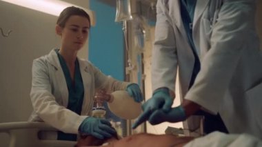 Hemşire hastane koğuşunda kalp masajına yardım ediyor. Klinik personeli hayat kurtarır