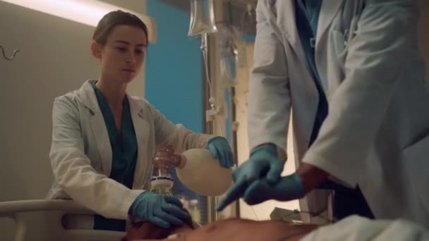 Enfermeira assistindo o processo de massagem cardíaca na enfermaria hospitalar. Equipe da clínica salvar a vida — Vídeo de Stock