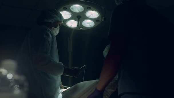 Cirujano profesional puntada incisión en quirófano. Equipo de unidad de cuidados intensivos — Vídeos de Stock