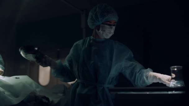 Chirurgo professionista che opera nel pronto soccorso buio. Cooperazione tra equipe mediche — Video Stock