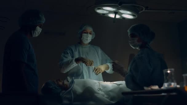 Медицинская команда проводит операцию в больничной палате. Инструменты для прохождения хирурга. — стоковое видео
