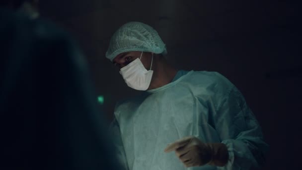 Cirujano masculino en quirófano comunicándose preparándose para tratamiento quirúrgico. — Vídeo de stock