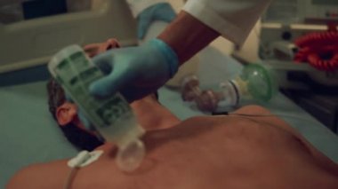 Acil serviste baygın bir adamı defibrilasyona sokan doktor elleri kapalı..