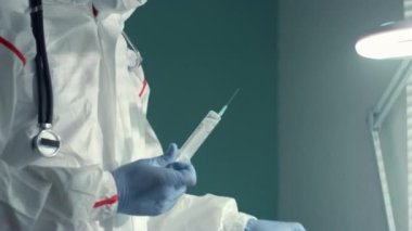 Doktor hastane bulaşıcı hastalıklar biriminde serum torbası kullanarak tıbbi şırınga çekti..