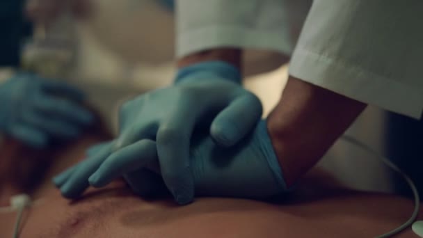 O médico reanima o paciente moribundo de perto. Massagem cardíaca no hospital — Vídeo de Stock