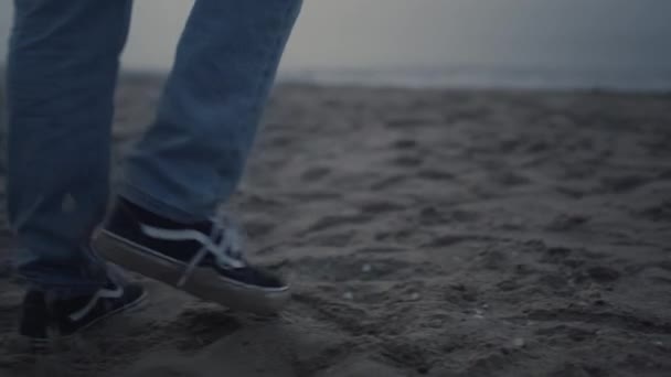 Pria berkaki dengan sepatu modis berjalan di pantai. Man feet exploring sea coast — Stok Video