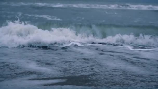 Meereswellen stürmen den Strand vor dunkelblauem Hintergrund. Gefährliches Naturkonzept. — Stockvideo