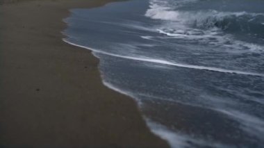Mavi dalgalar kumsal manzarasına deniz kıyısını vuruyor. Vahşi doğa konsepti.