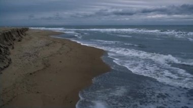 Akşam karanlığında deniz manzarası çok güzel. Dalgalar kıyıya vuruyor.