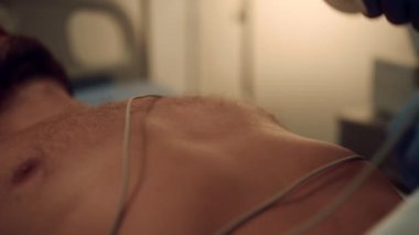 Doktor hastanın göğsüne EKG kablosu bağladı. Hastanenin kalp tedavisi.