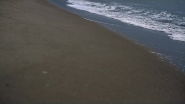 Strandvågor kraschar längs kusten. Havsskum stormar blå strand natur bakgrund. — Stockvideo