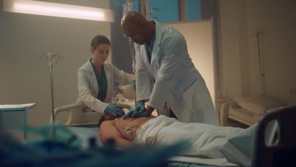 Doktor acil serviste kalp masajı yapıyor. Hemşire oksijen maskesi takıyor.. — Stok video