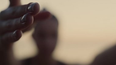 Formda kadın plajda yoga yaparken el ele tutuşuyor. Kız jimnastik yapıyor