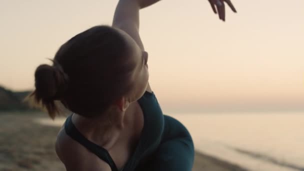 Sportovní žena představení utthita trikonasana na pláži letní ráno zblízka. — Stock video