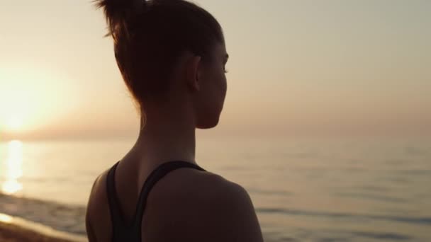 Chica en forma de primer plano meditando en el cielo al atardecer delantero. Mujer deportiva practicando yoga. — Vídeo de stock