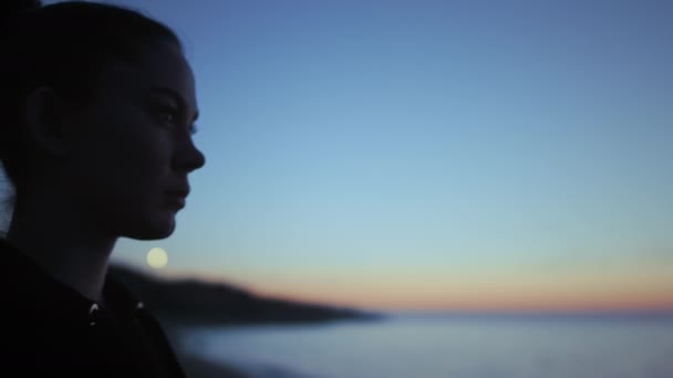 Szoros nő sziluett álló strand naplementekor. Jóga lány élvezi a kék eget. — Stock videók