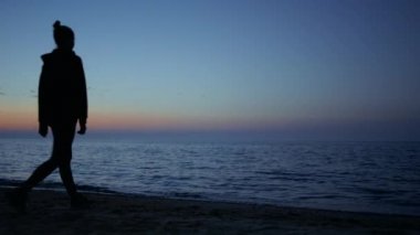 Bilinmeyen Yogi kadın deniz kıyısında dinlenme egzersizi yapıyor. Güzel bir akşam..