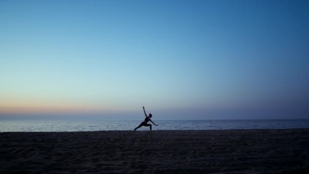 Sziluett jóga nő edzés harcos ászana előtt gyönyörű naplemente ég. — Stock videók