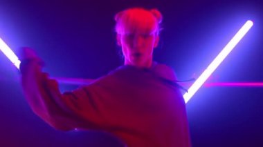 Modern hiphop yapan bir kız neon ışıklarda hareket eder. Serbest dans eden sanatçı kadın.