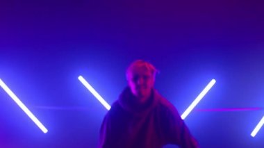 Neon arka ışıklandırmayla sokak dansı yapan adam. Şık break dansçı serbest stil seviyor..