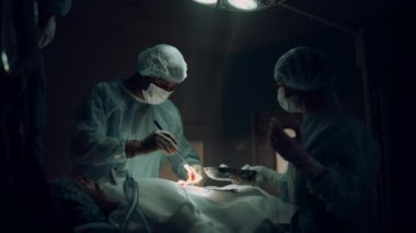 Karanlık hastane acil servisinde tıbbi personel ameliyat yapıyor..