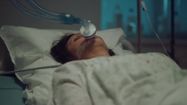 Patient with oxygen mask lying hospital bed in hospital intensive care unit. — Stock Video